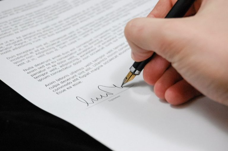 person signing a paper